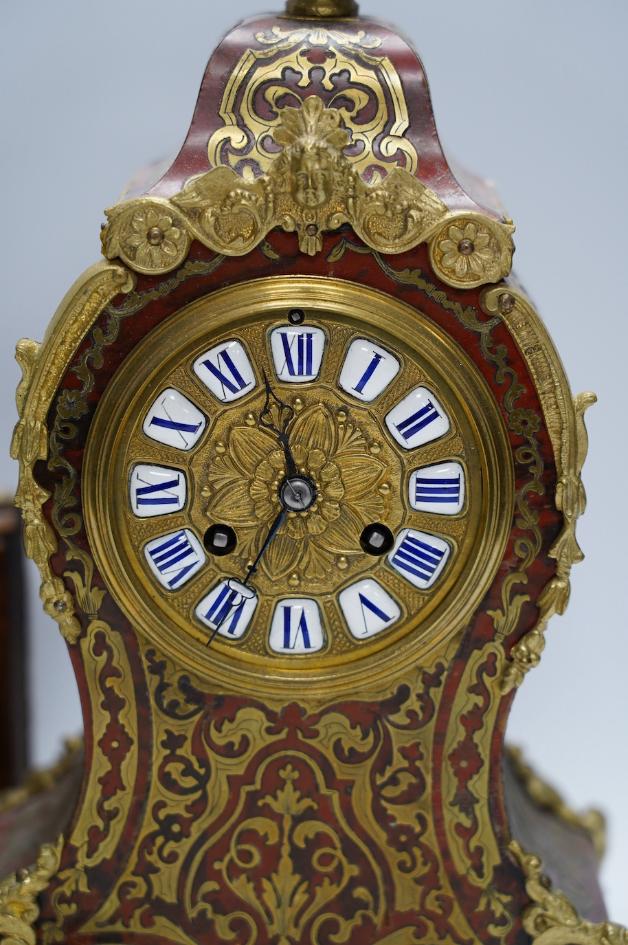 A Louis XV style red boulle eight day mantel clock, with bracket and pendulum, clock 30cm high. Condition - fair, not tested